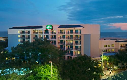 a hotel building with a green sign on top of it at Courtyard by Marriott Cocoa Beach Cape Canaveral in Cocoa Beach