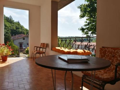 um pátio com uma mesa e cadeiras e uma varanda em Villa Miranda em Santa Fiora
