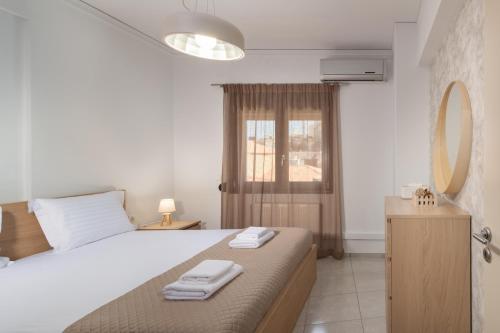 ein Schlafzimmer mit einem Bett mit zwei Handtüchern darauf in der Unterkunft Korai City Vibes in Iraklio