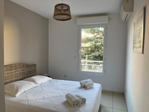 une chambre blanche avec un lit avec des serviettes dessus dans l'établissement Alice, à Cannes