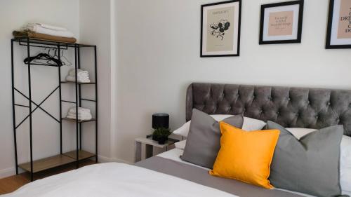 a bedroom with a bed with an orange pillow at N&K Yellow Pearl Flat in Volos