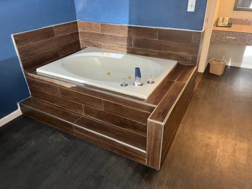 a bath tub in a bathroom with a wooden floor at Key West Inn - Roanoke in Roanoke