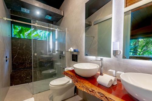 a bathroom with a sink and a toilet and a shower at Noah's Forest Hotel by Tifakara in Fortuna