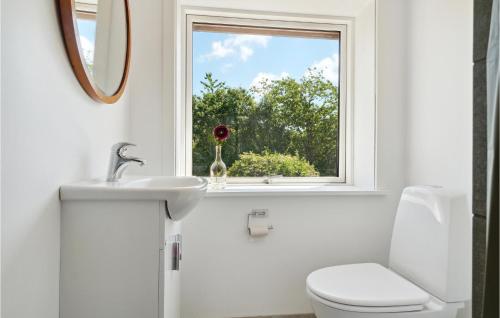 a bathroom with a white toilet and a window at 2 Bedroom Nice Apartment In Aakirkeby in Åkirkeby