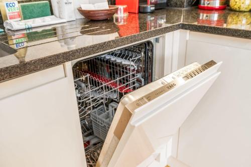 an open dishwasher in a kitchen counter at Bright & Spacious Battersea Flat in London