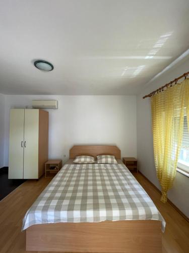 - une chambre avec un lit et une couverture à damier dans l'établissement Maki, à Vir