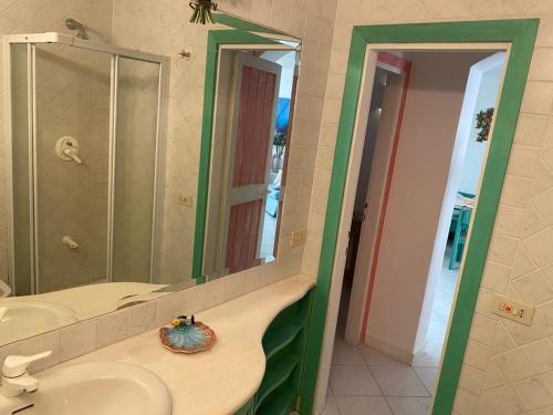 a bathroom with two sinks and a large mirror at Residence Baja Sardinia in Baja Sardinia