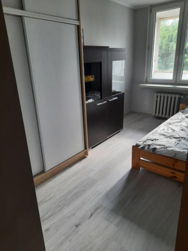 - une chambre avec un lit et un grand miroir dans l'établissement mieszkanie w Giżycku, à Giżycko