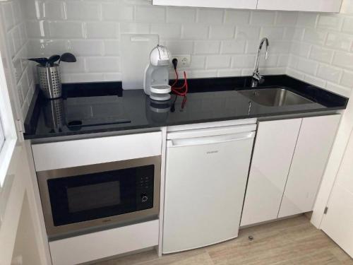 a small kitchen with a sink and a microwave at Castellana 4 torres Apartments in Madrid