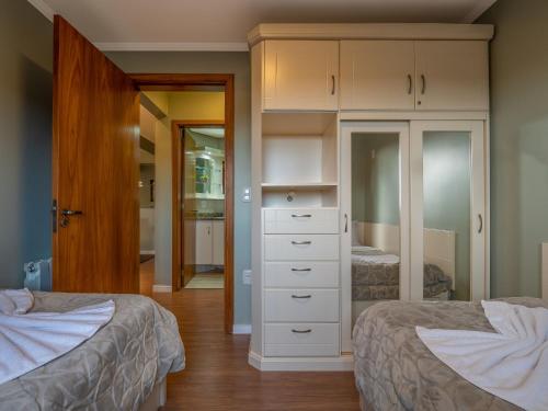 een slaapkamer met 2 bedden en een witte dressoir bij Sierra Nevada - 501 in Gramado