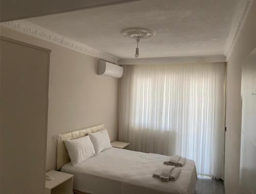 a bedroom with a white bed and a window at Royal Asalet Suites - شقق الأصالة الملكية in Trabzon