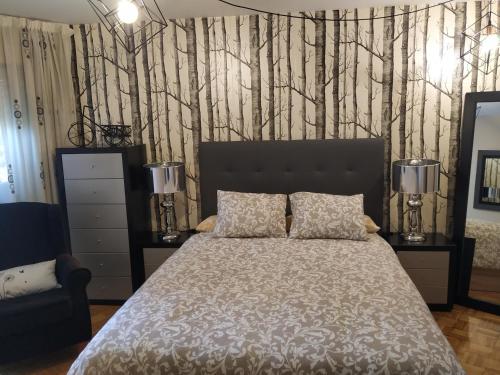 a bedroom with a bed and trees on the wall at Ría del Burgo in Cambre