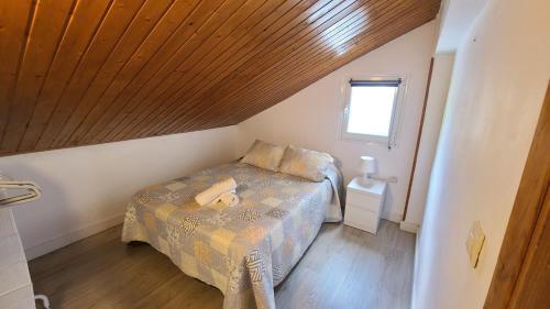 um pequeno quarto com uma cama e um tecto em madeira em Apartamento rural en Espinosa de los Monteros em Espinosa de los Monteros
