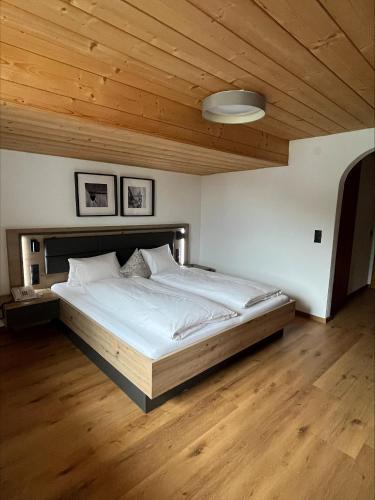 a bedroom with a large bed with a wooden ceiling at Ferienwohnung Florina im Hotel Casada in Galtür