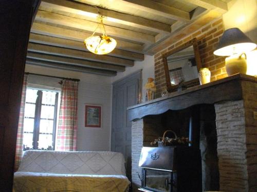 a living room with a fireplace and a mirror at Gîte du Domaine de Chateux in Soumans