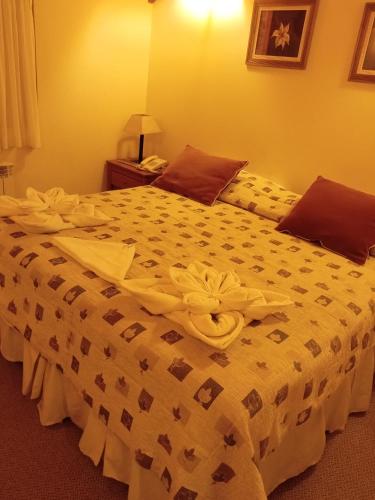 a bedroom with a large bed with a white comforter at Hotel Spa Nieves Del Cerro in Caviahue