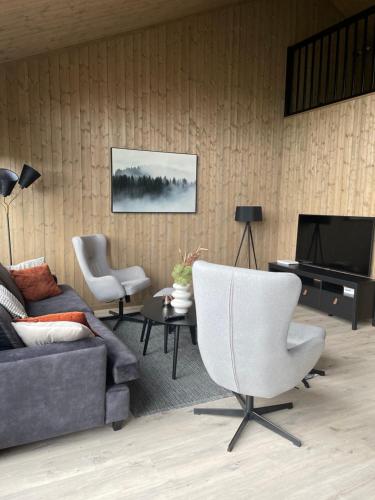 a living room with a couch and a television at Skaidi Logde- near salomon river and golf course in Hammerfest