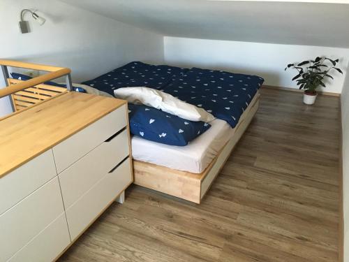 a small bedroom with a bed and a dresser at Apartma BAUI Koper in Koper