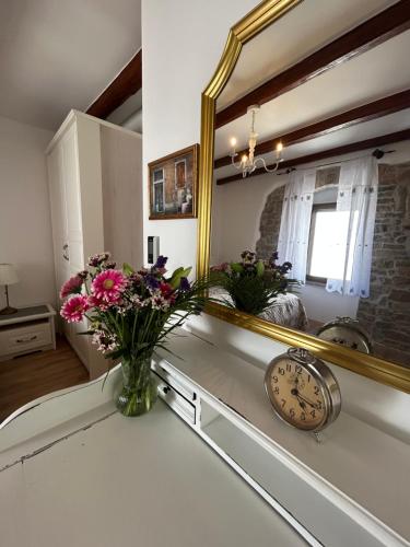 Casa Stella في Draguch: حمام به مرآة و مزهرية من الزهور