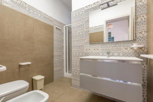 y baño con aseo, lavabo y espejo. en Villa Althea by BarbarHouse, en San Pietro in Bevagna