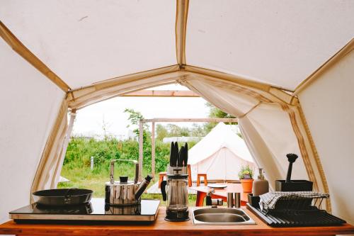 eine Küchentheke mit einer Spüle in einem Zelt in der Unterkunft DOMO CAMP Sylt - Glamping Camp in Westerwall