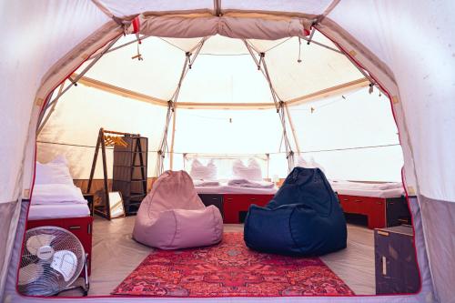 a tent with two beds and a rug in it at DOMO CAMP Sylt - Glamping Camp in Westerwall