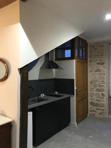 - une cuisine avec un évier et une porte en bois dans l'établissement La maison de Lea, chambres d'hôtes de 14 couchages, à Tournus