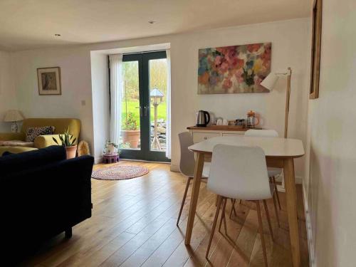 LlanwrdaCrymlyn barn的客厅配有桌子和桌椅