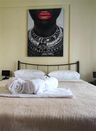 a bed with a picture of a woman with red lipstick at Didda's Apartment in Orfánion