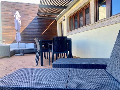 un patio con sedie blu, un tavolo e un edificio di Misericórdia Garden Homes a Vila do Conde