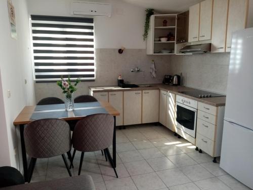 uma cozinha com uma mesa e cadeiras e um frigorífico em Apartment Lil em Podstrana