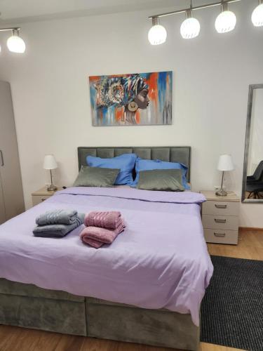 una camera da letto con un grande letto con lenzuola e cuscini viola di APARTMAN ZAGREB cca 42m2 with free parking a Zagabria
