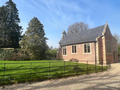 an old brick church with a fence in front of it at Old School House - Luxury 4 bed holiday home near Norwich, Norfolk in Lingwood