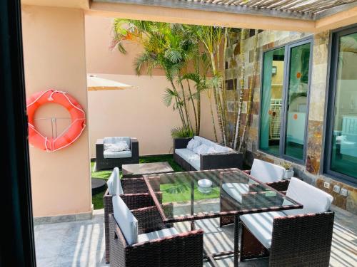 un patio con tavolo in vetro e sedie di Villa mit Pool Los Lagos 16 a Salobre