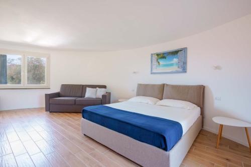 a bedroom with a large bed and a couch at B&B Villa Zola in Capoterra