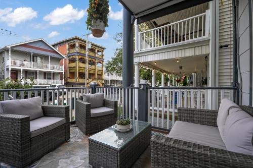 een patio met rieten stoelen en tafels op een balkon bij The Inn at Ocean Grove in Ocean Grove