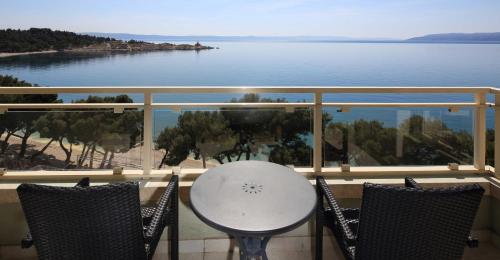 a balcony with a table and chairs and a view of the water at Hotel Park Makarska in Makarska