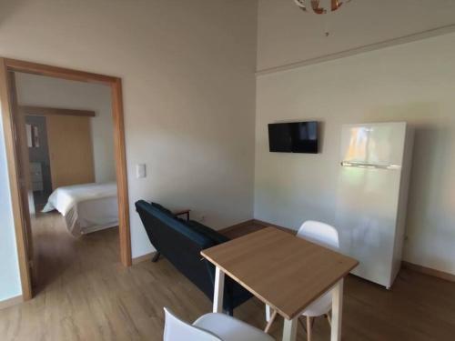 a room with a table and a refrigerator and a bed at Quinta das Bicas AL in Angra do Heroísmo