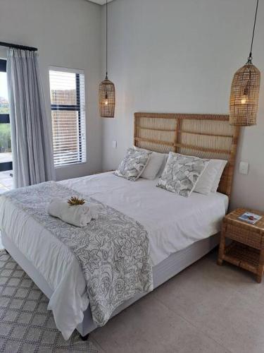 a bedroom with a large bed with white sheets and pillows at Golfers Haven Studio Apartment in Langebaan