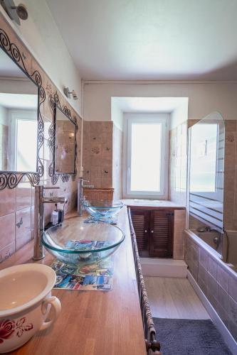 La salle de bains est pourvue d'un lavabo en verre et d'une baignoire. dans l'établissement Pyrénées Boutx - Grand Gîte de caractère, à Boutx