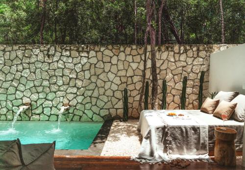 a bedroom with a bed and a swimming pool at The Lund Tulum in Tulum