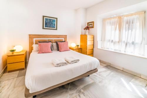 a bedroom with a large bed with two towels on it at AlohaMundi Almansa in Seville