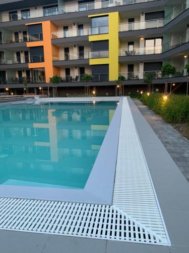 an empty swimming pool in front of a building at Római Ház Apartman in Siófok