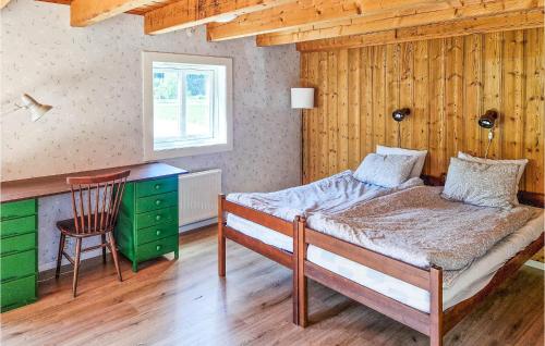 1 dormitorio con cama, escritorio y silla en 3 Bedroom Amazing Home In Vrigstad en Vrigstad