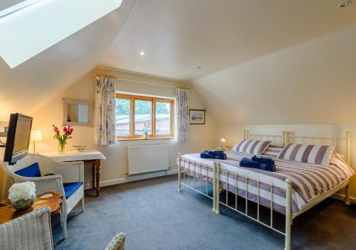 a bedroom with a bed and a desk and a window at Brights Farm Lodge in Bramfield