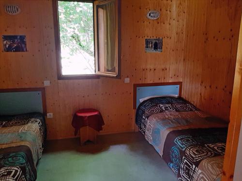 a room with two beds and a window at Gites dans La Prairie in Junhac