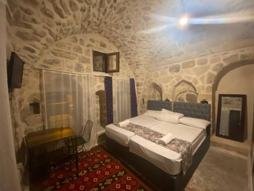 馬爾丁的住宿－Gılgamesh butik otel，石头间内一间卧室,配有一张床