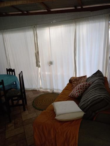 a bed in a room with white curtains at Casa temporada próximo à parque in Penha