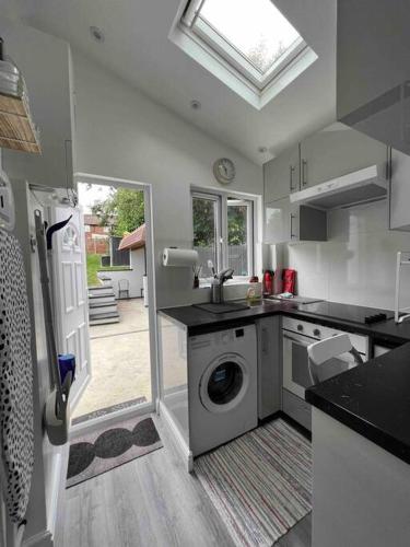 a kitchen with a washing machine and a sink at Studio apartment/flat in Chislehurst