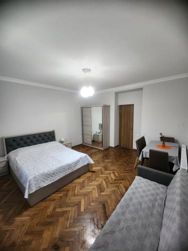 1 dormitorio con cama, mesa y sofá en Comfortable Apartment close to Central Park en Tskaltubo